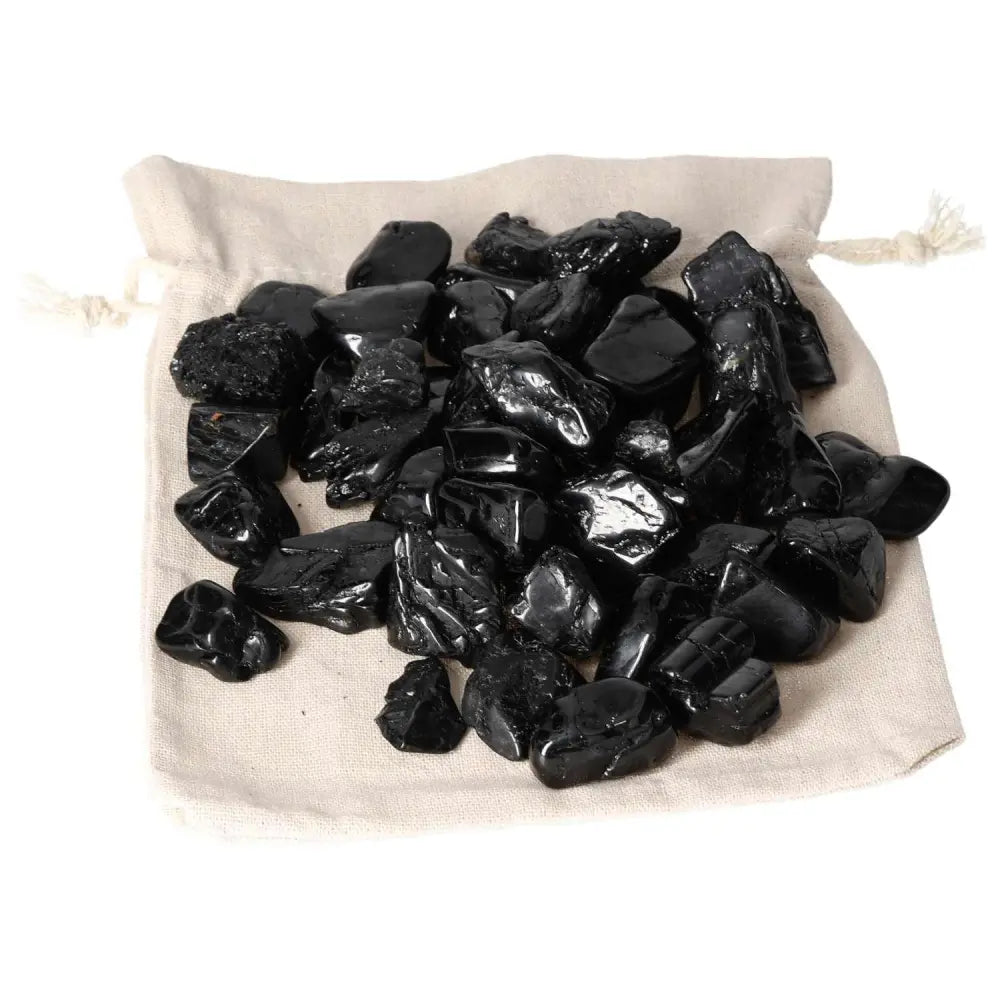 Black tourmaline stones on a cloth bag showcasing premium Sylvia Crystals product for spiritual protection and grounding.