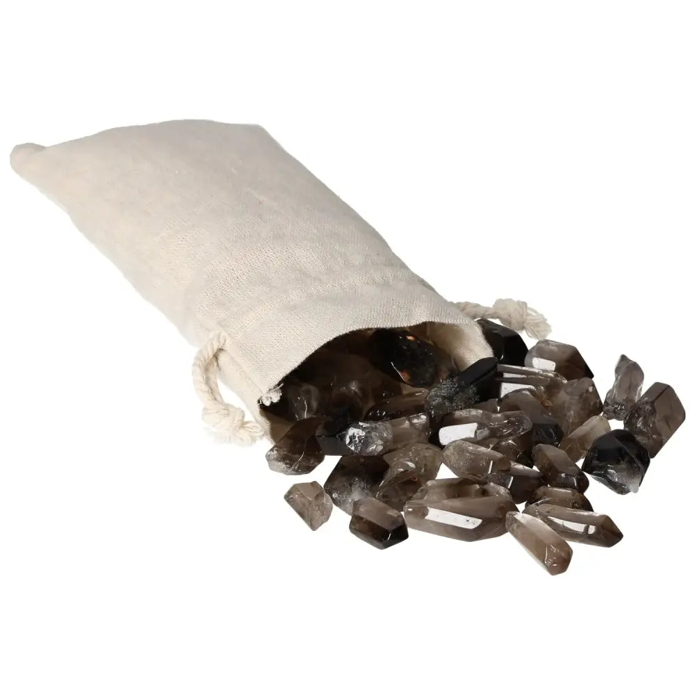 A collection of tumbled smoky quartz points spilling from a cloth bag, showcasing their natural beauty and grounding properties.