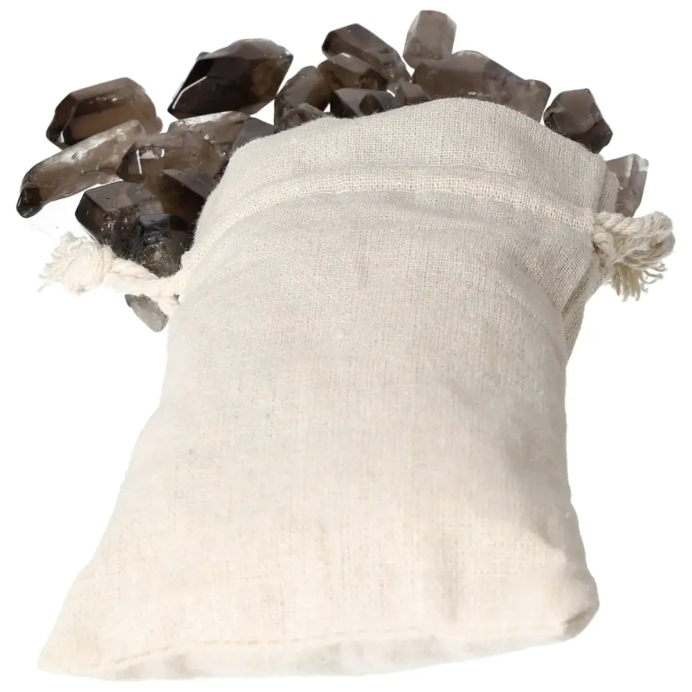 Tumbled Smoky Quartz Points spilling from a white linen bag, showcasing premium crystals for collectors from Sylvia Crystals.