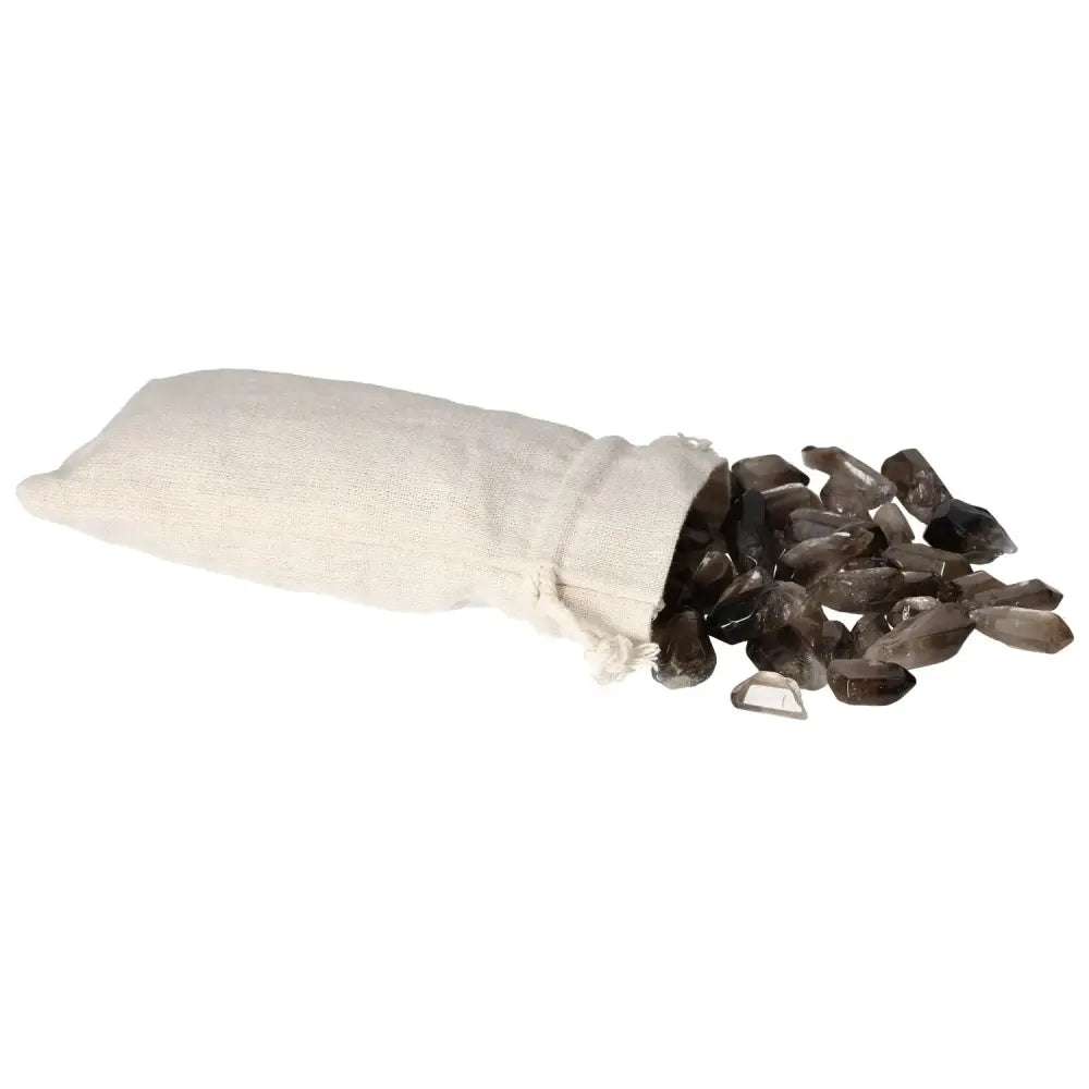 A linen pouch spilling tumbled smoky quartz points, highlighting their polished surfaces and color variations, from Sylvia Crystals.