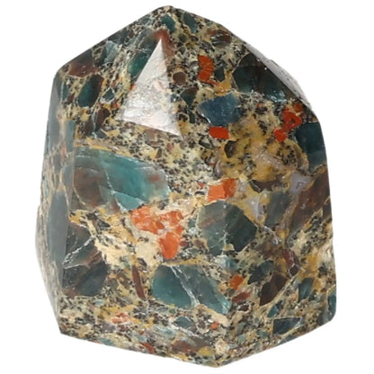Multicolored stone obelisk featuring a blend of green, orange, and brown tones, showcasing intricate natural patterns.