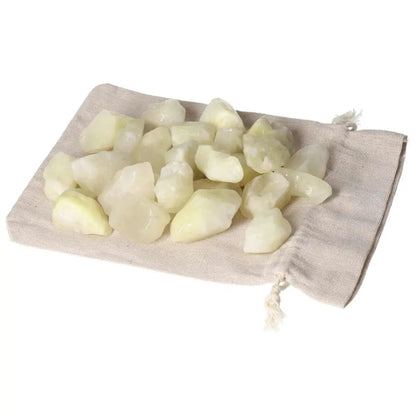 Tumbled Sulphur crystals on a fabric pouch, showcasing vibrant yellow hues and representing purity and cleansing.