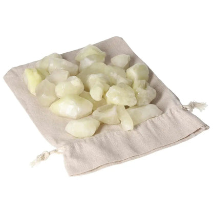 Tumbled Sulphur crystals on a beige drawstring pouch, symbolizing purity and cleansing. Premium Sylvia Crystals product.