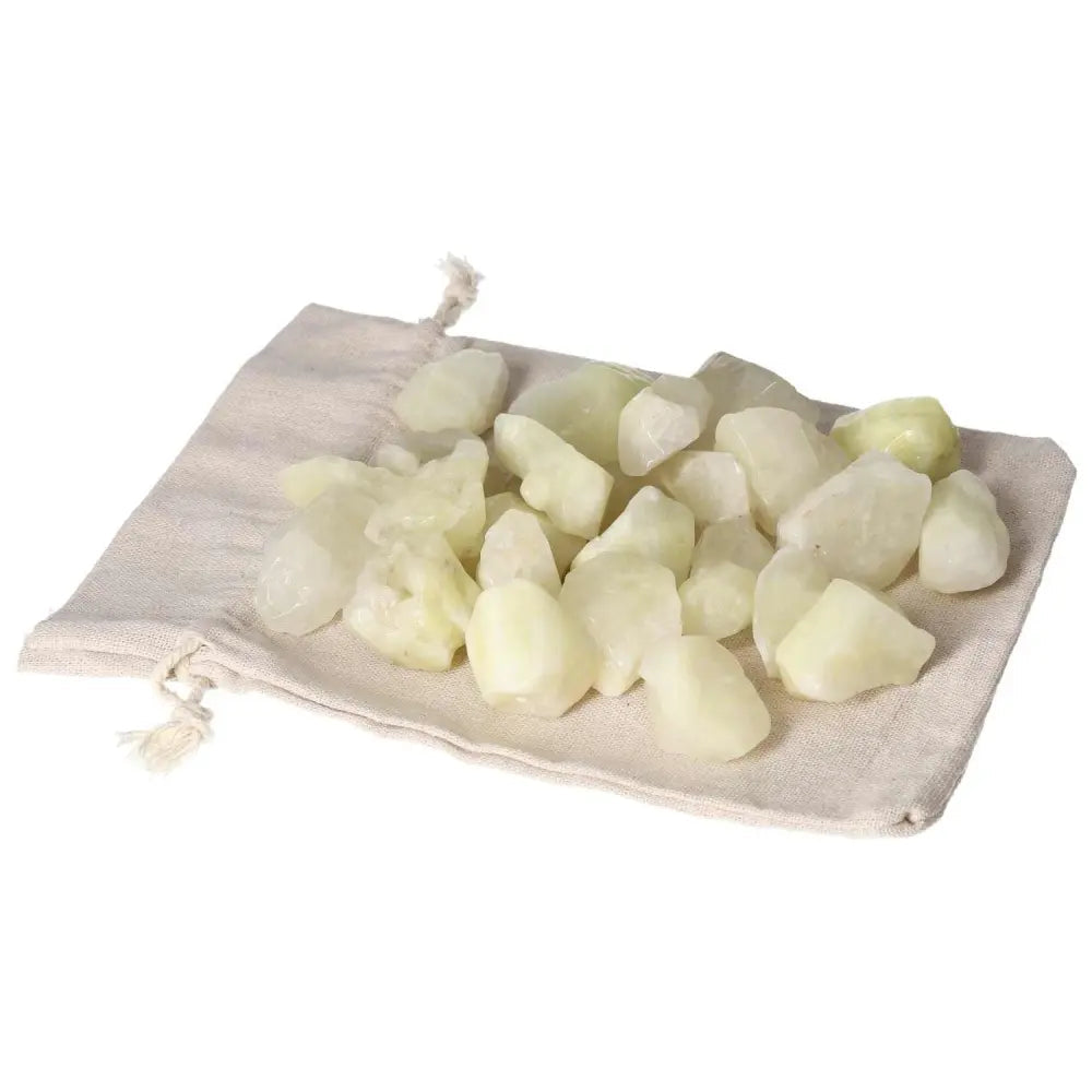 Tumbled Sulphur crystals on a beige pouch, showcasing their vibrant yellow hue and premium quality from Sylvia Crystals.