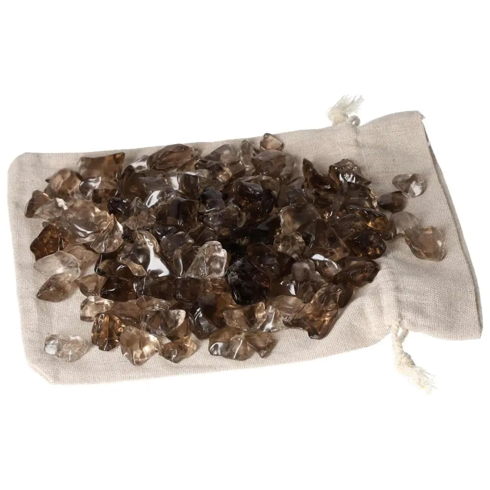 Tumbled Smoky Quartz crystals on a beige fabric pouch, ideal for grounding and enhancing practical thinking.