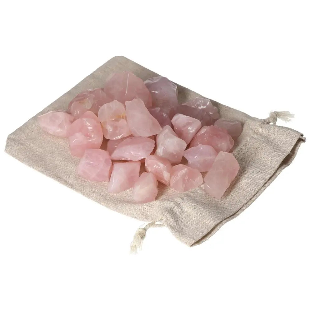 Tumbled Rose Quartz stones on a linen pouch, promoting emotional healing and love, from Sylvia Crystals collection.