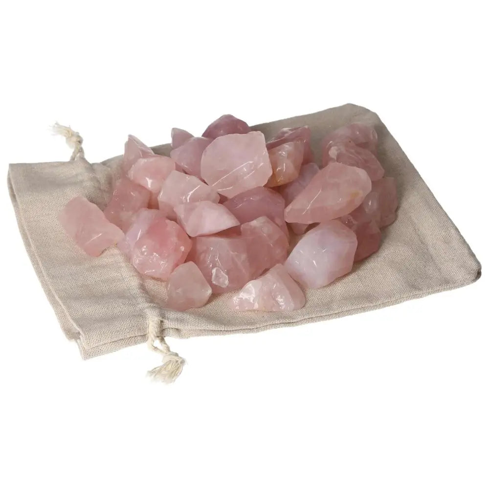 Tumbled Rose Quartz stones from Sylvia Crystals on a beige pouch, symbolizing love and emotional healing.