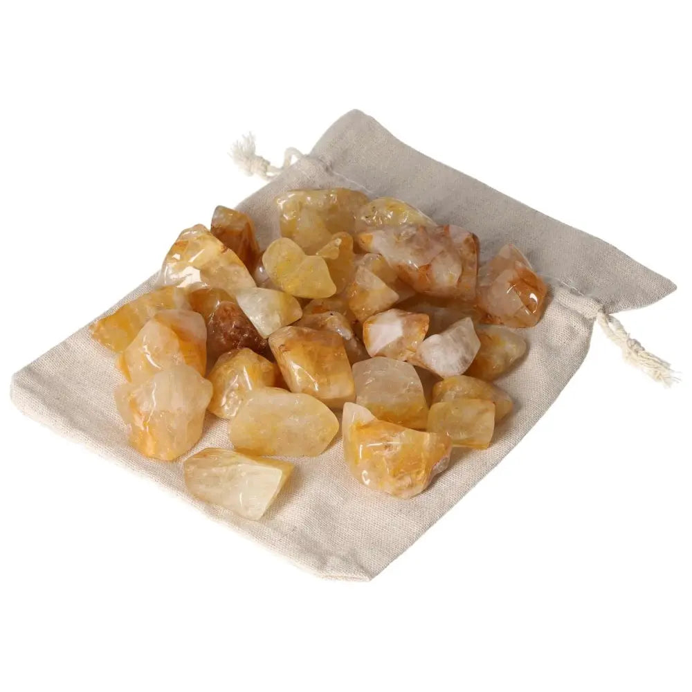 Tumbled Yellow Hematoide crystals on a fabric pouch from Sylvia Crystals, showcasing golden hues and spiritual elegance.