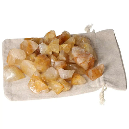 Tumbled Yellow Hematoide crystals from Sylvia Crystals on a linen pouch, showcasing their golden hues and luxurious appeal.