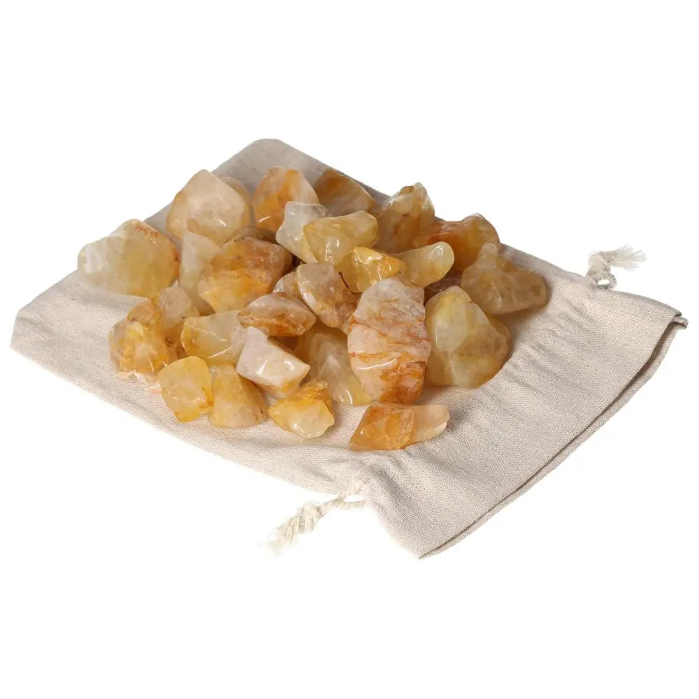 Tumbled Yellow Hematoide crystals on cloth bag, premium gem from Sylvia Crystals, known for elegance and luxury in spiritual harmony.