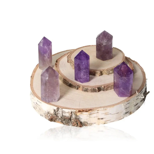 Amethyst Obelisks on rustic wooden stand, showcasing deep purple hues and luxurious elegance from Sylvia Crystals, enhancing spirituality.