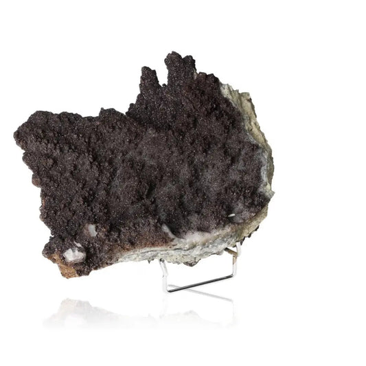 Black Calcite crystal formation on a stand, known for energy amplification and spiritual growth properties.