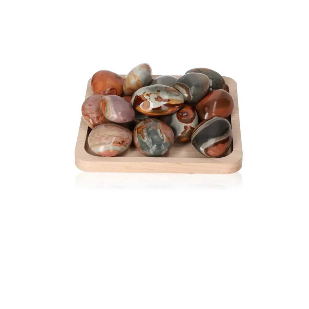 Polychrome Jasper gemstones on a tray showcasing vibrant colors and dynamic patterns, known as Desert Jasper.