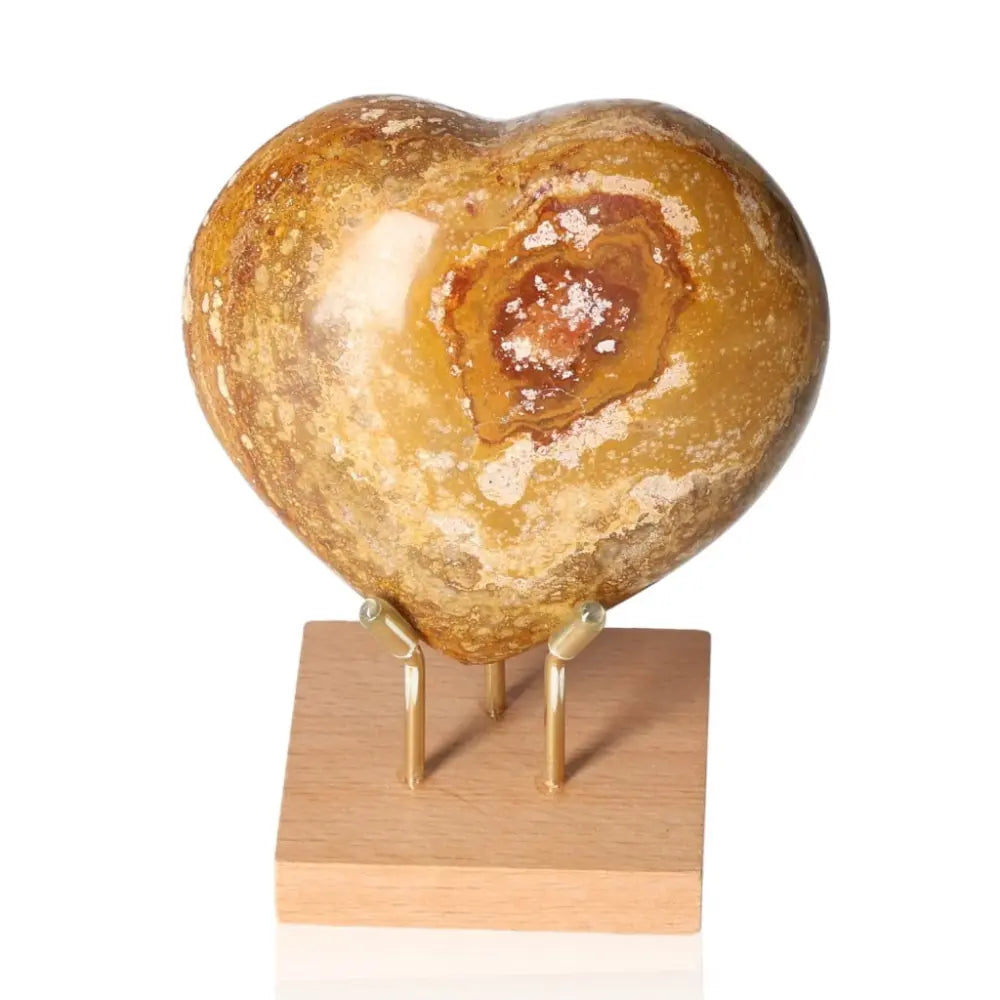 Ocean Jasper Heart gemstone with mesmerizing patterns on a stand, known for promoting joy and positivity.