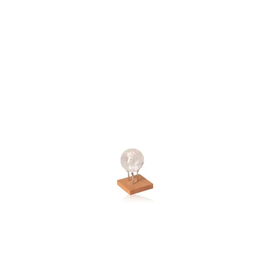 Lemurian Quartz Sphere on wooden stand, capturing light and reflection for meditation, purity, and clarity in spiritual practices.