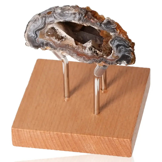 Mini Agate Geode on wooden stand showcasing natural crystalline interior, enhancing spaces with harmonizing energy and aesthetic charm.