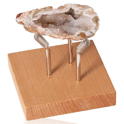 Mini Agate Geode on wooden stand, showcasing natural crystal formation for energy balance and well-being enhancement.