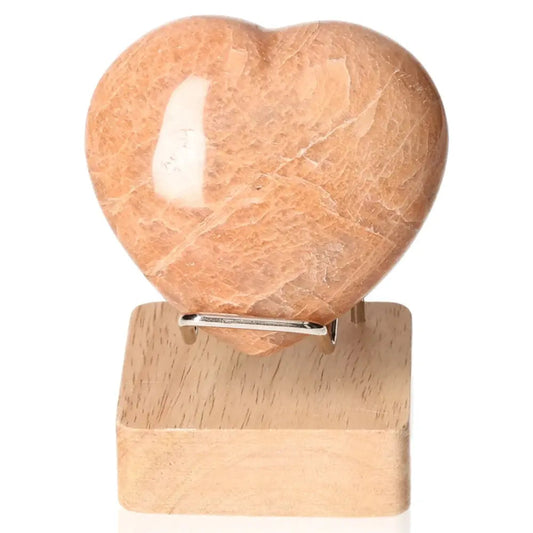 Peach Moonstone Heart for emotional balance and intuition on a wooden stand, enhances attractiveness and protects against nightmares.