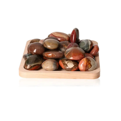Polychrome Jasper palm stones with multicolored patterns on a wooden tray, promoting tranquility and balance.