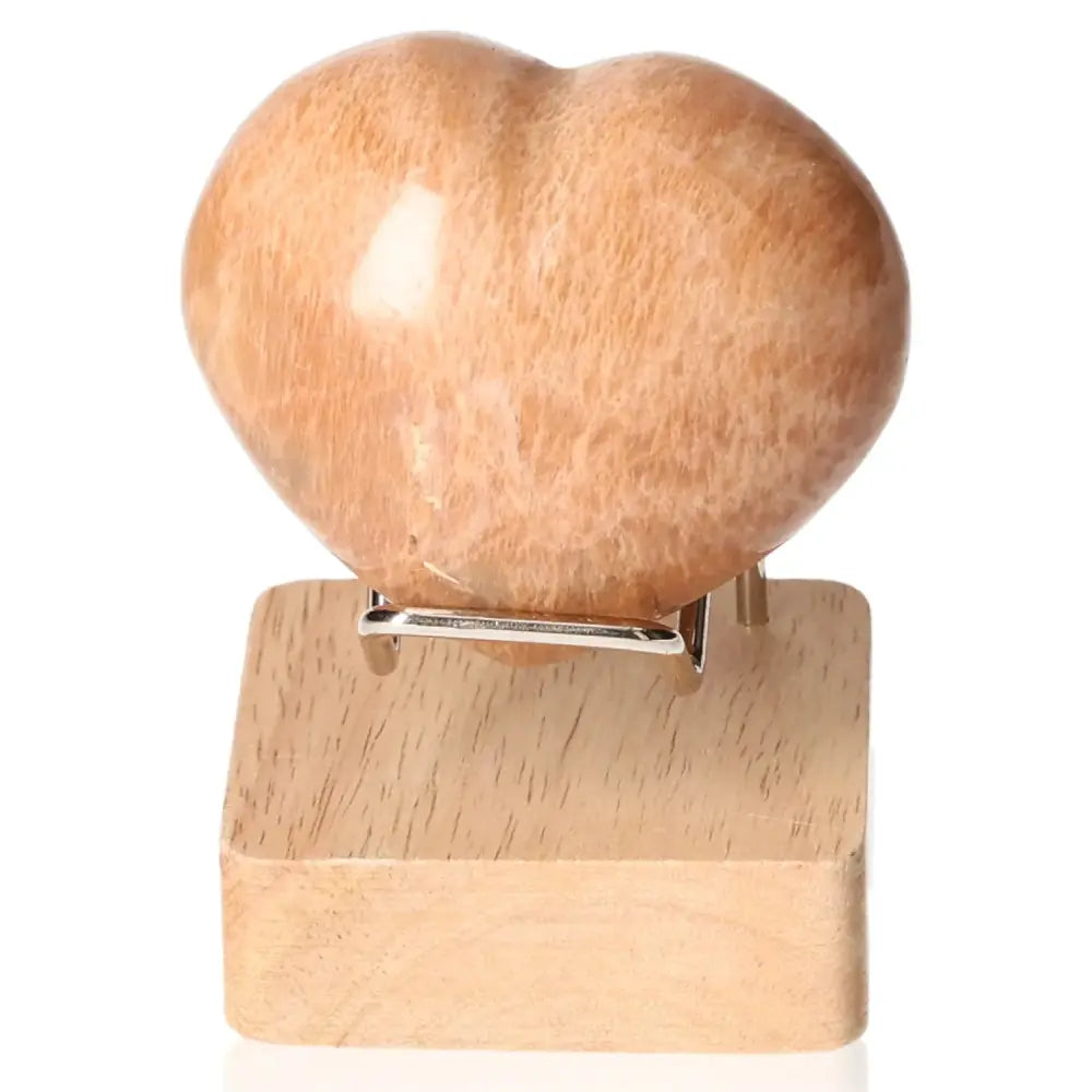 Peach Moonstone Heart on stand highlighting emotional balance and intuition, ideal for attraction and nightmare protection. Stand not included.