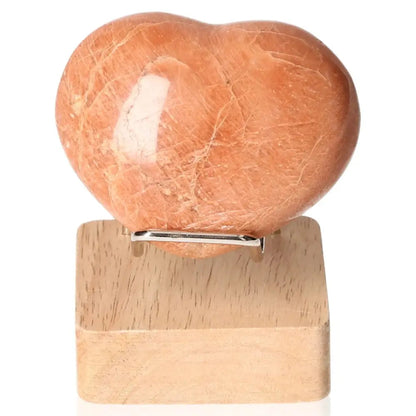 Heart-shaped peach moonstone on stand, promoting emotional balance and intuition, ideal for enhancing sensitivity and peaceful sleep.