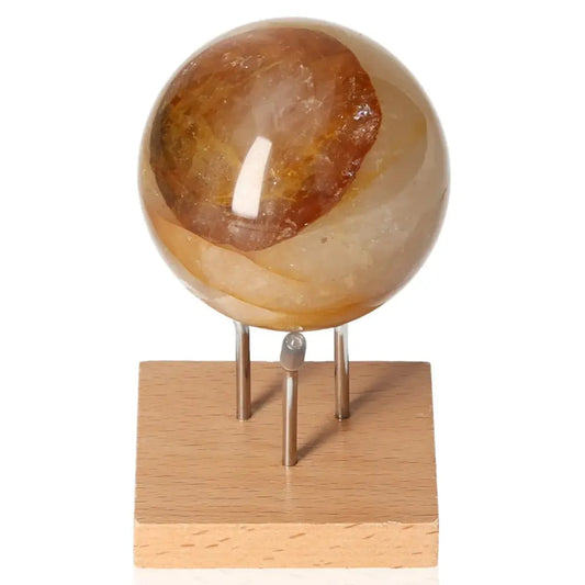 Honey Calcite Quartz Sphere on wooden stand, premium gemstone from Sylvia Crystals showcasing luxury and spiritual synergy.