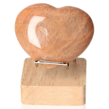 Peach Moonstone Heart on wooden stand, enhances emotional balance, intuition, and protects against nightmares, not including stand.
