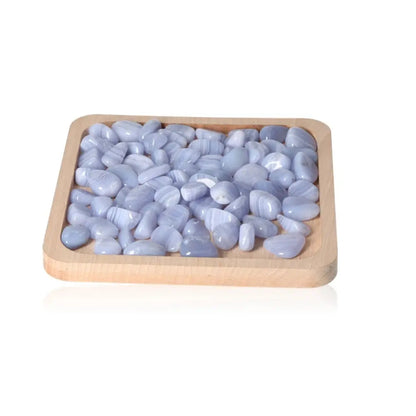 Tumbled Blue Chalcedony stones arranged on wooden tray for emotional balance and tranquility.