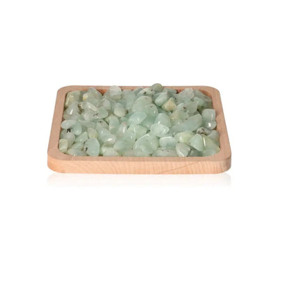 Tray of Tumbled Prehnit S gemstones showcasing soothing pale green hues, known for calming and soothing energy.