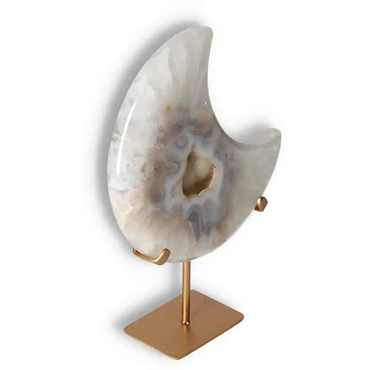 Agate lunar crescent with translucent layers and geode center, on a gold stand, illuminating with ethereal elegance.