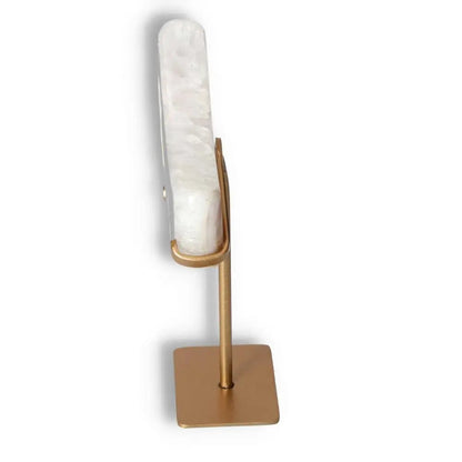 Side view of agate lunar crescent sculpture on a stand, displaying natural geode formation and white swirls of translucent agate.