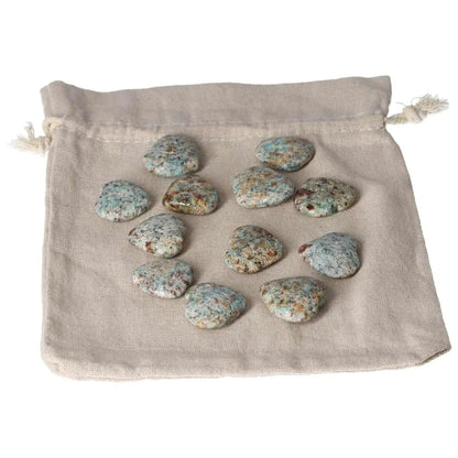 Collection of small Amazonite heart stones on a beige pouch, known for harmony and balancing emotions, offering a calming effect.