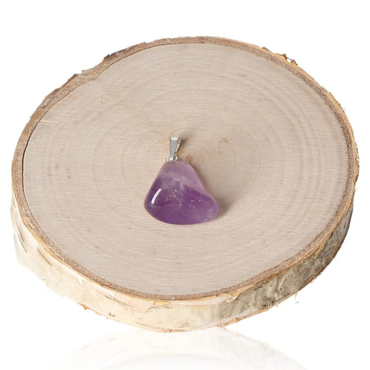 Amethyst Tumbled Pendant featuring a polished amethyst stone, displayed elegantly on a wooden slice, showcasing natural elegance and tranquility.