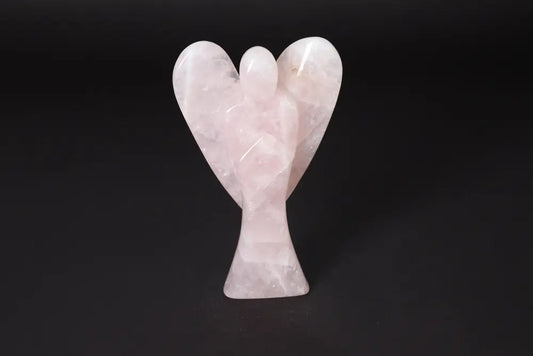 Rose Quartz angel figurine 15 cm tall on a black background, known for harmonizing energy and neutralizing negative vibrations.
