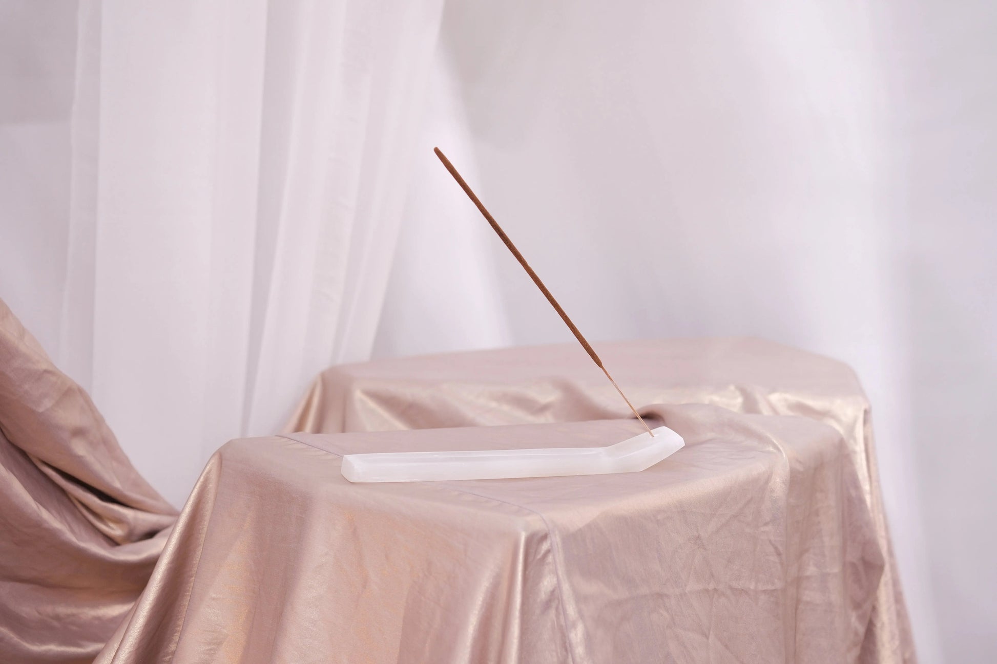 Elegant display of Bali Harmony Incense Blend stick on a satin-draped table, embodying serenity and traditional Balinese craftsmanship.
