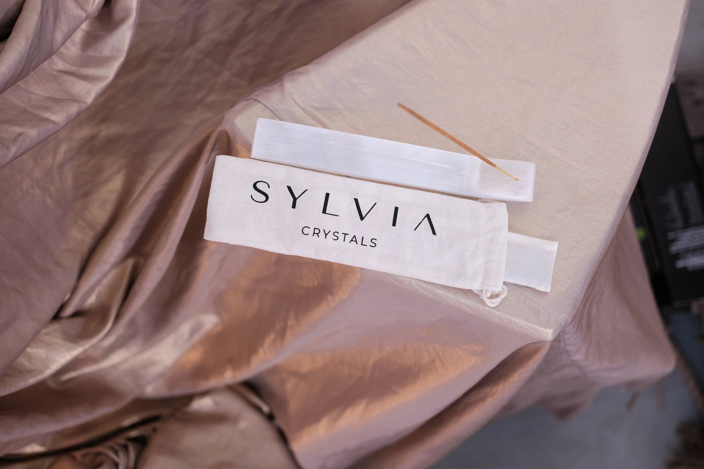 Sylvia Crystals packaging with incense stick on silk fabric, enhancing serenity and elegance, perfect for spiritual ambiance.