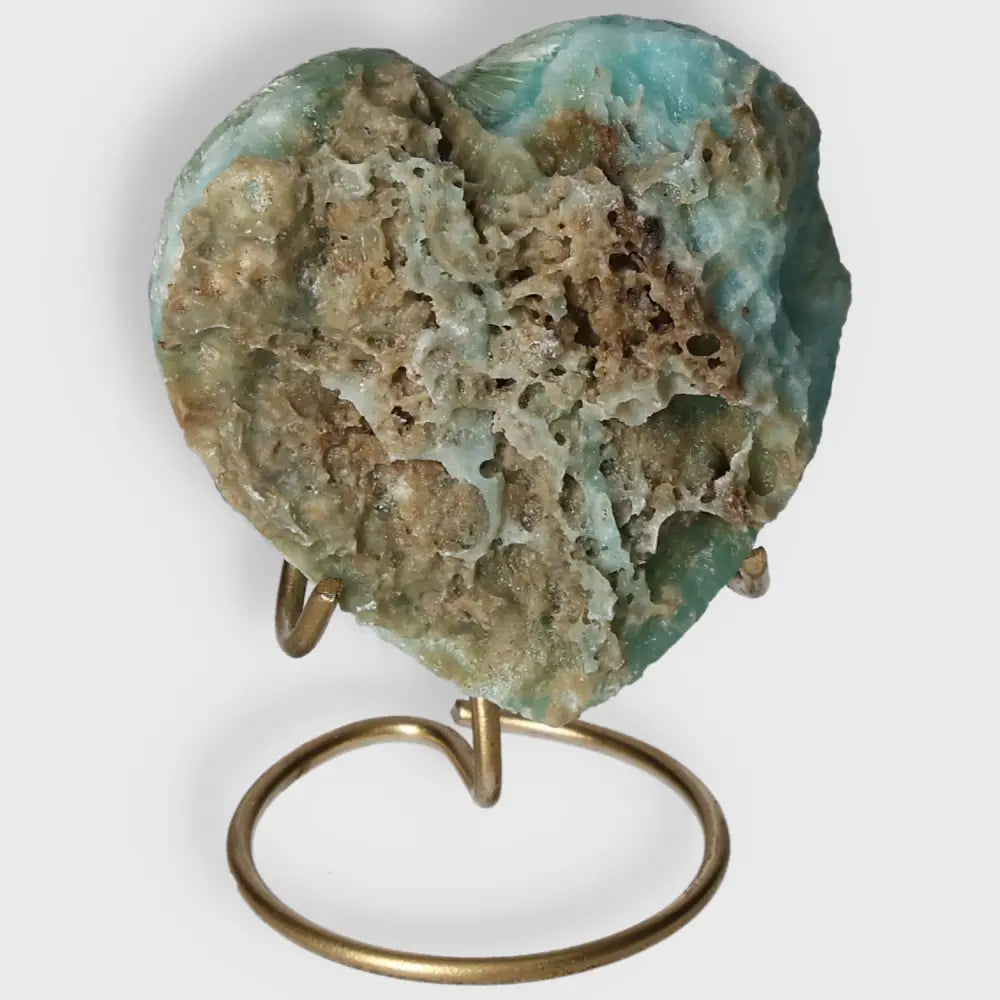 Blue Aragonite Heart crystal with soothing blue hues on display stand, symbolizing emotional balance and clear communication.