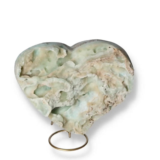 Blue Aragonite Heart gemstone with natural patterns, promoting tranquility and emotional balance, displayed on a stand.
