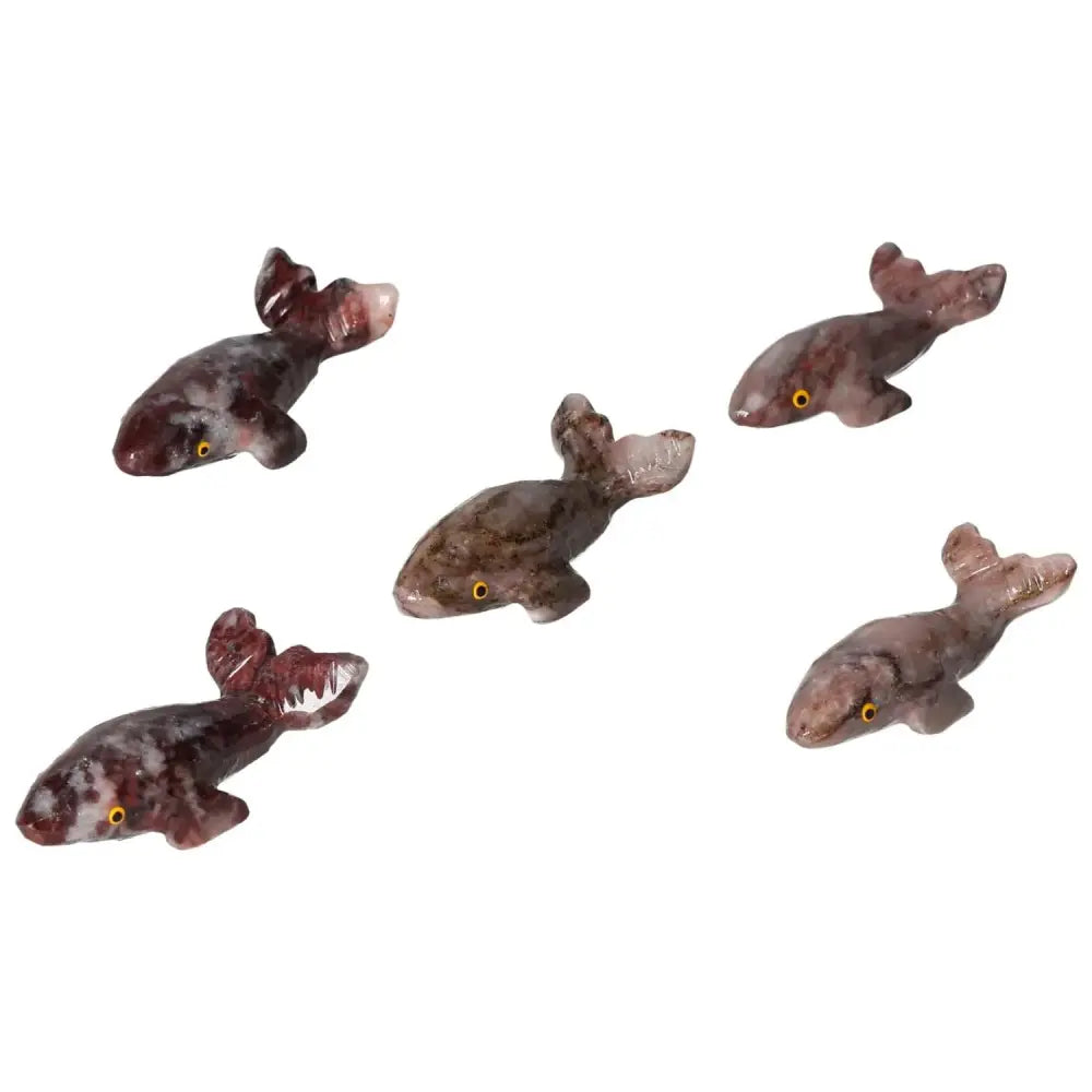 Handcrafted carved magnesite whale figurines in various shades of brown, symbolizing tranquility and elegance from Sylvia Crystals.