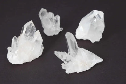 Clear Quartz Cluster set of 5 on dark background, radiating high energy and purity, perfect for amplifying intentions and harmony.