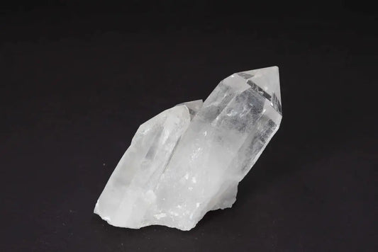 Clear Quartz Cluster with multiple crystal points on a dark background, amplifying energy and enhancing harmony in any space.