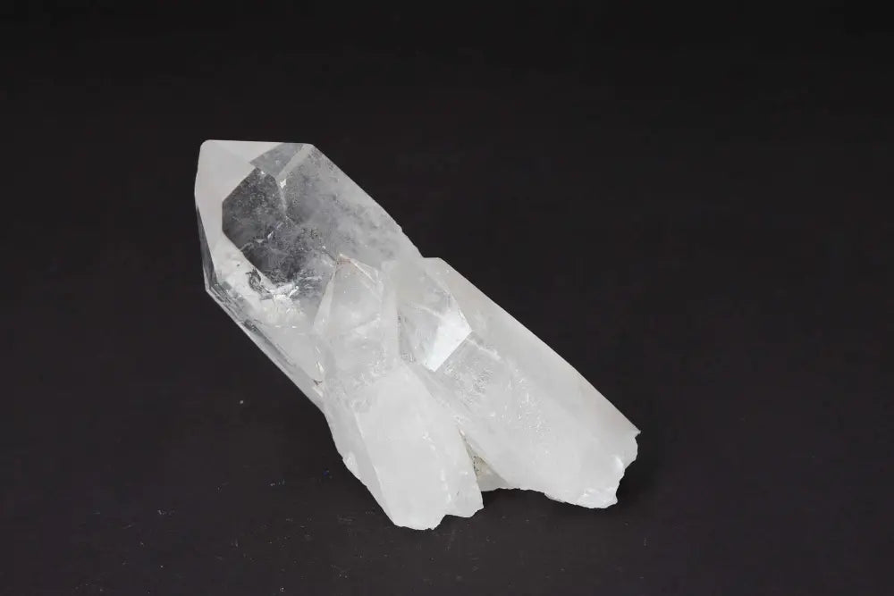Clear Quartz Cluster on black background, amplifying energy and radiating clarity for spiritual harmony.