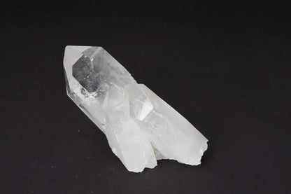 Clear Quartz Cluster on black background, amplifying energy and radiating clarity for spiritual harmony.