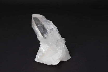 Clear Quartz Cluster on dark background, radiating clarity and high vibrational energy, ideal for amplifying intention and purifying spaces.