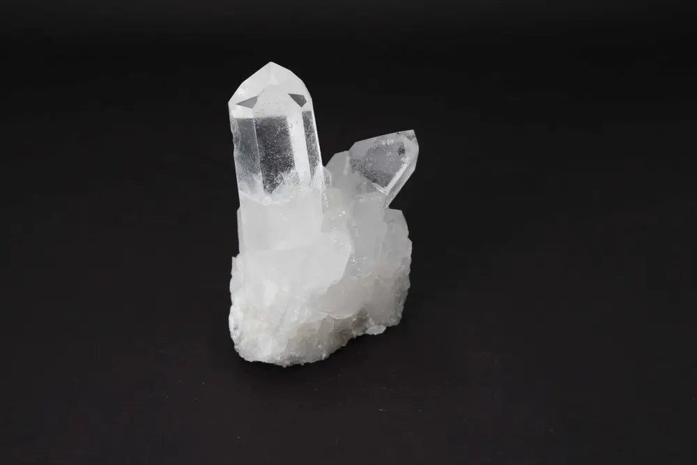 Clear Quartz Cluster crystal on dark background, showcasing its natural beauty and energy amplifying properties.