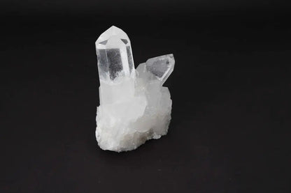 Clear Quartz Cluster crystal on dark background, showcasing its natural beauty and energy amplifying properties.