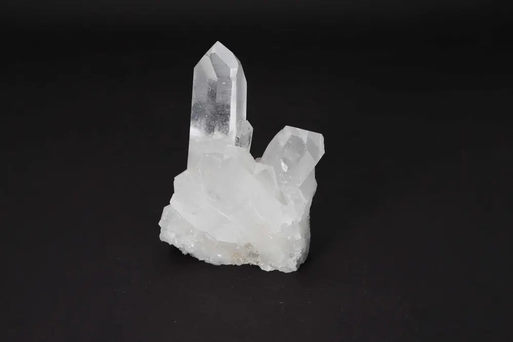 Clear Quartz Cluster with crystal points, radiating clarity and energy on a dark background, ideal for amplifying intention and purifying spaces.