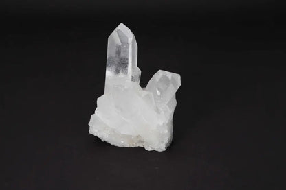 Clear Quartz Cluster with crystal points, radiating clarity and energy on a dark background, ideal for amplifying intention and purifying spaces.