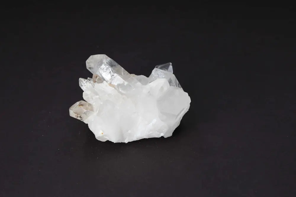 Clear Quartz Cluster on dark background amplifying energy and clarity with multiple crystal points enhancing harmony and purity.