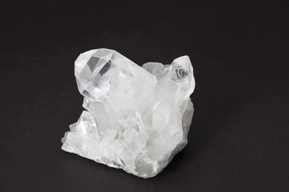 Clear Quartz Cluster crystal on dark background, showcasing natural formations with multiple points and high vibrational energy.
